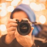 man holding Canon DSLR camera