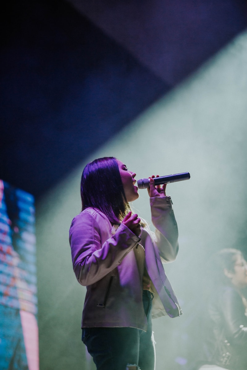 Photo by Nicolas Lobos girl holding microphone close-up photography