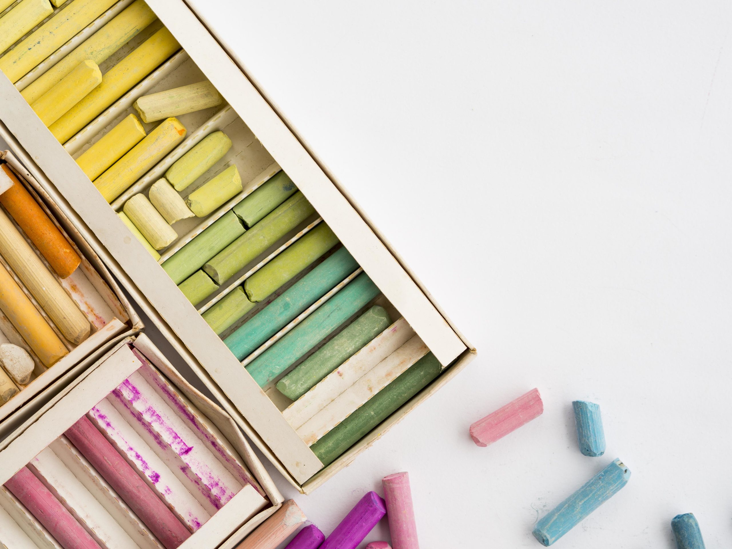 flat-lay-box-with-colorful-chalk-copy-space assorted-color oil pastel with two white papers